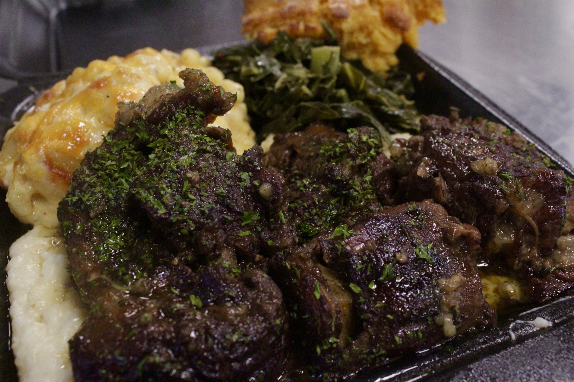Oxtails with mac and cheese, greens, and cornbread